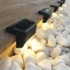Solar Step Lights Waterproof Performance in Rain Waterproof solar step lights working in rain, installed on garden edge with pebbles