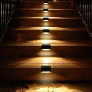 Outdoor solar step lights installed on wooden stairs, warm white LED illumination for patio and garden safety lighting