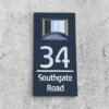 Black personalised LED house number plaque 34 Southgate Road, flat lay view on concrete surface