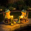 Two frog rocking chair solar LED lights placed on garden patio at night